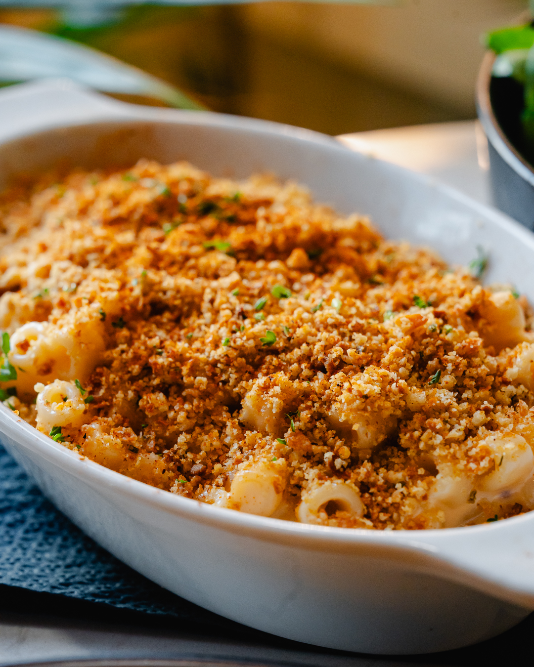 Baked macaroni and cheese with a golden breadcrumb topping in a white oval baking dish